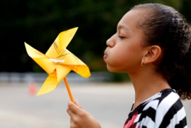 Fifth-grader Nia Steadwell tries to blow a pinwheel before planting it in the grass outside of Carthage Elementary School Sept. 20. Steadwell and her classmates planted 450 pinwheels made by students in pre-k through fifth grade in celebration of the International Day of Peace.